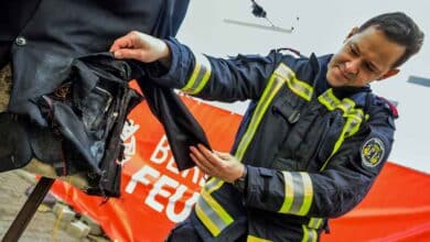 Ein Feuerwehrmann zeigt den Schaden, nachdem ein illegaler Böller in der Jacke einer Attrappe bei einer Demonstration der Berliner Feuerwehr zum richtigen Umgang mit Feuerwerk am 29. Dezember 2022 in Berlin explodierte. (Foto von John MACDOUGALL / AFP)
