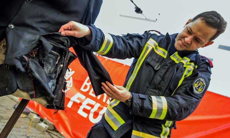 Ein Feuerwehrmann zeigt den Schaden, nachdem ein illegaler Böller in der Jacke einer Attrappe bei einer Demonstration der Berliner Feuerwehr zum richtigen Umgang mit Feuerwerk am 29. Dezember 2022 in Berlin explodierte. (Foto von John MACDOUGALL / AFP)